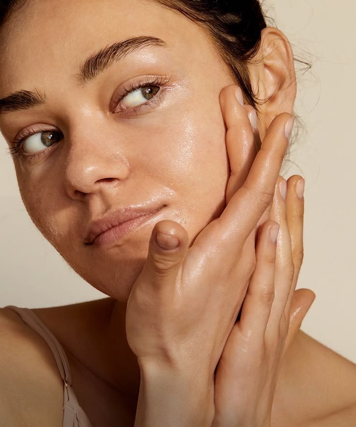 Mujer aplicándose crema hidratante en el rostro