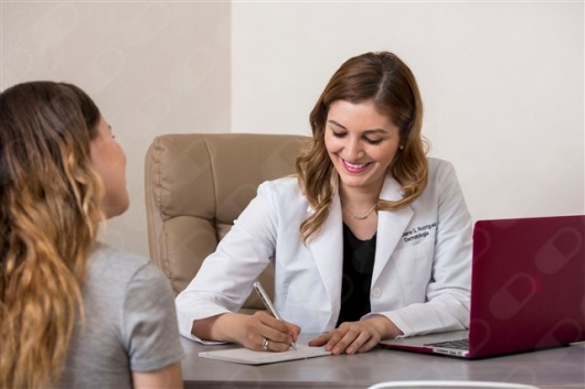 Dermatóloga en consulta con una paciente